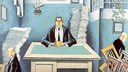 picture of man at desk surrounded by paper